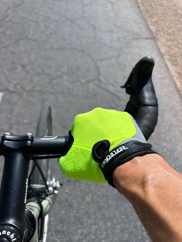 Cyclist’s hand in a fluorescent reflective glove on the handlebar