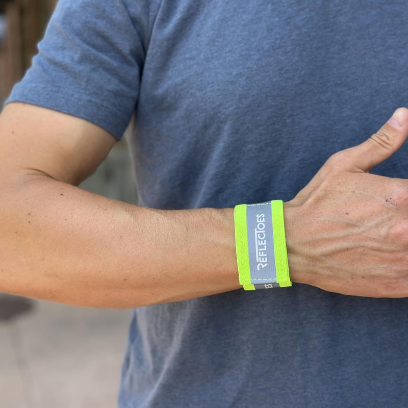 Man wearing neon yellow reflective wrist safety band on his right wrist outdoors