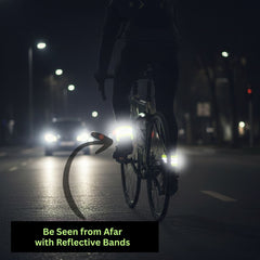 Night cyclist with reflective bands on legs and wrists glowing under car headlights