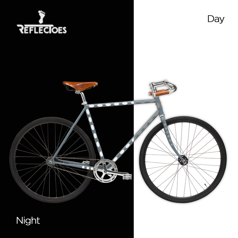 Dark bicycle with ReflecToes reflective oval stickers on frame glowing white at night comparison